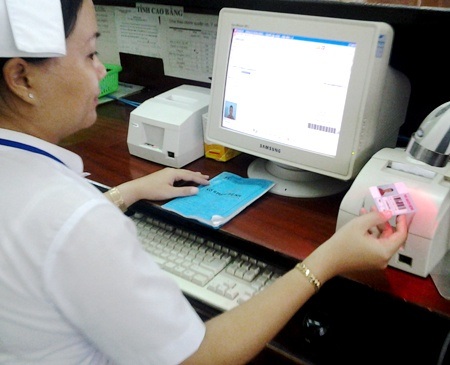 Triển khai thẻ khám bệnh điện tử đầu tiên tại khu vực Đồng bằng Sông Cửu Long - 1 Nhân viên bệnh viện đang quét thẻ khám bệnh của bệnh nhân đến khám bệnh.