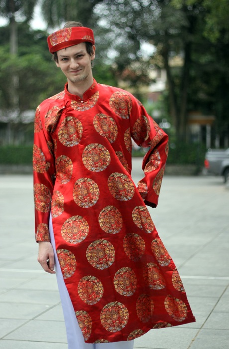 Một chàng trai mặc thử trang phục áo the, khăn xếp