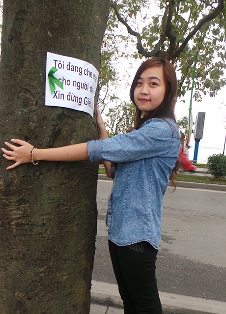 Thành viên nhóm tình nguyện ôm cây thể hiện tình yêu với một Hà Nội xanh