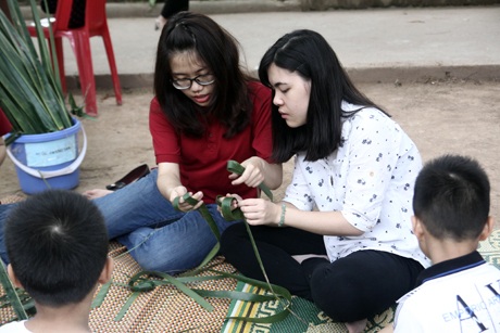 Các cô gái chăm chú tập làm cào cào lá tre.