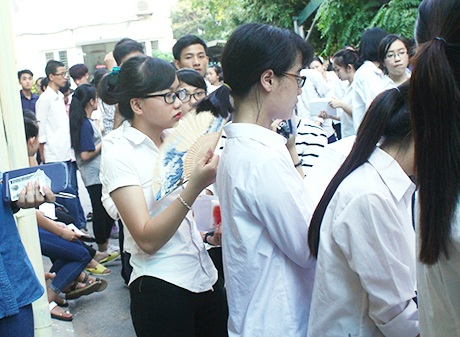 Thí sinh cũng luôn tay quạt mát trong lúc xếp hàng đợi vào phòng thi