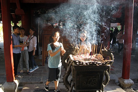 Bên cạnh dâng hương, cầu nguyện, một vài sĩ tử và người nhà còn xin sớ cầu may