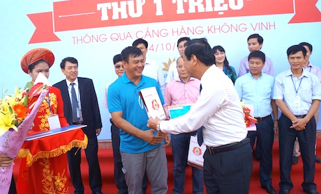 Cảng hàng không Vinh đón vị khách thứ một triệu năm 2014 - 2 Ông Nguyễn Hồng Kỳ (áo trắng) - GĐ Sở GTVT Nghệ An tặng quà cho hành khách 1.000.001.