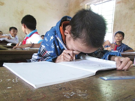 Cậu bé tật nguyền dùng việc học quên đi nỗi đau - 6 Trên lớp học, mỗi khi viết vào vở là Lộc phải dí sát mặt.
