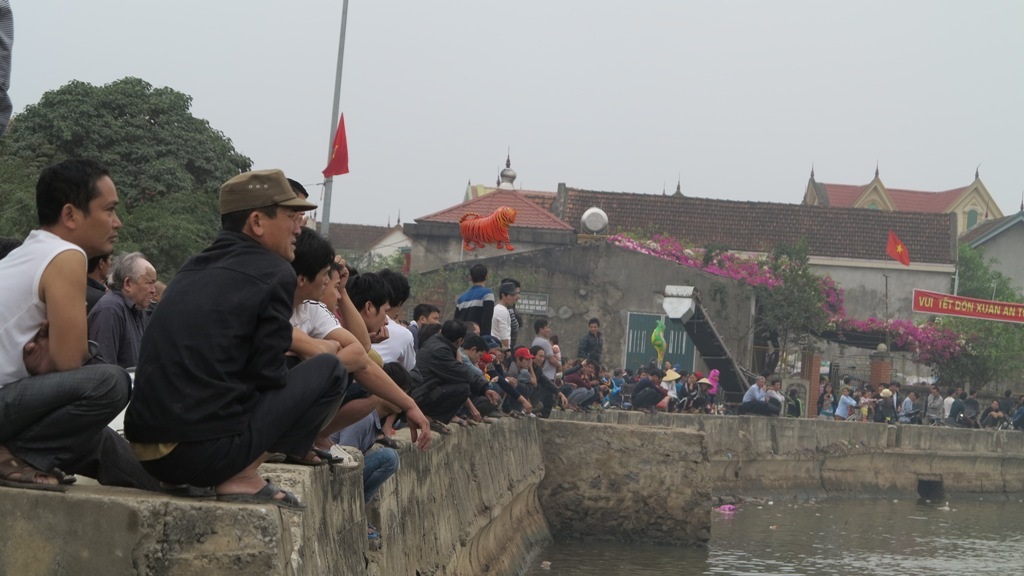 Người dân đứng trên bờ xem rước lễ hội cầu ngư.