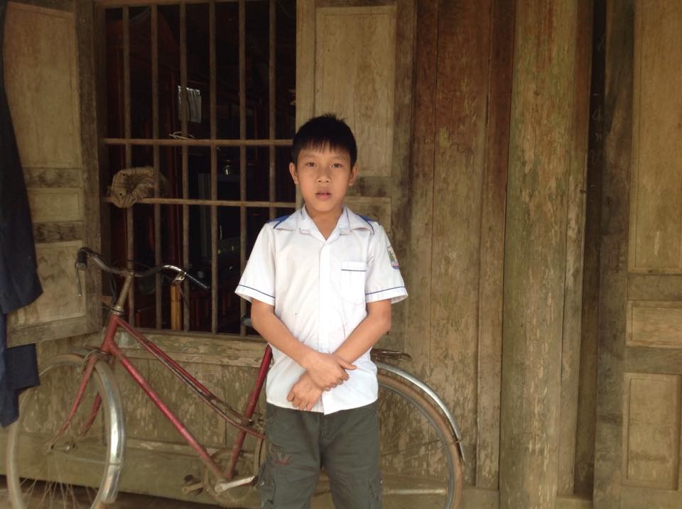 Cậu học sinh nghèo trả lại 20 triệu đồng nhặt được - 1 Em Tuấn trước căn nhà gỗ đơn sơ của gia đình.