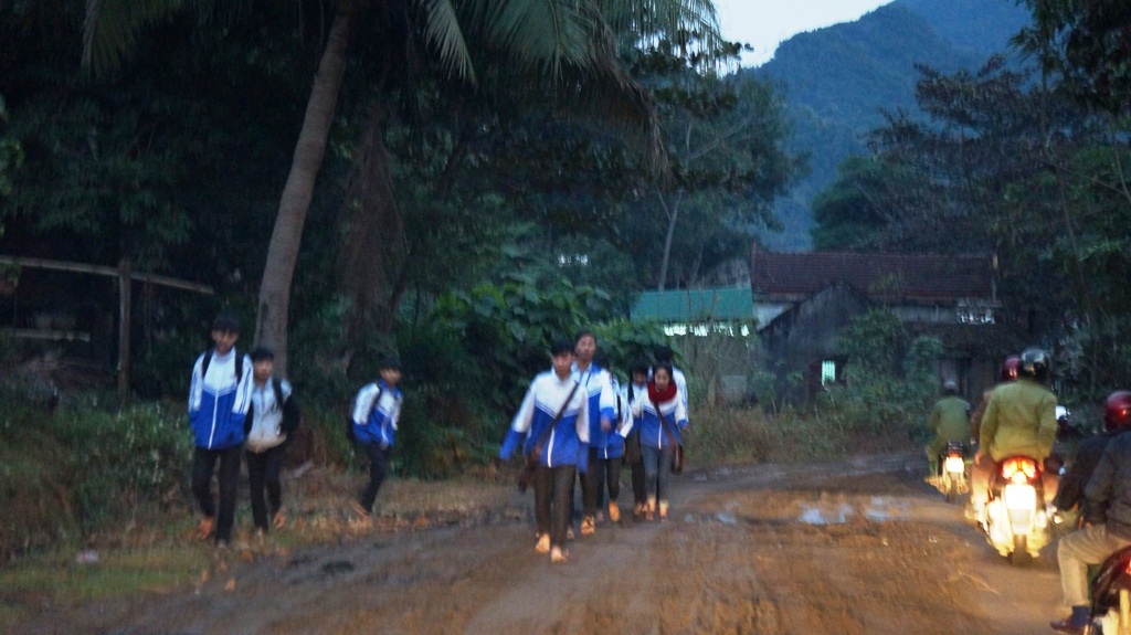 Học sinh đi bộ trên cung đường lầy lội.