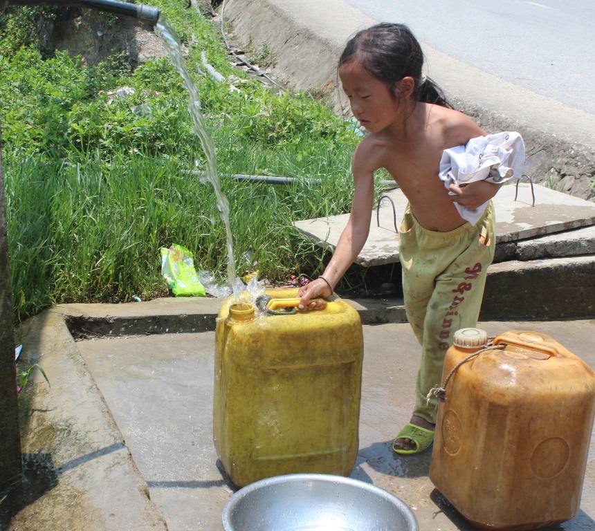 Những em bé phải thay bố mẹ đi xa lấy nước về để dùng.