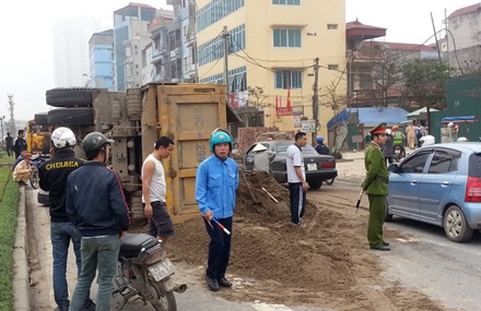 Xe tải chở cát lật nghiêng giữa đường