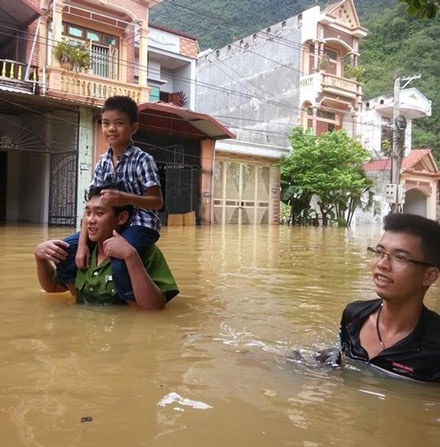 Ít nhất 14 người chết, 9 người bị thương sau bão số 3 - 6 Một chiến sĩ CA Hà Giang kiệu em nhỏ thoát khỏi vùng lũ (Ảnh: Tuấn Hợp)