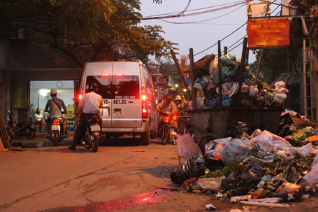 Người và xe chen nhau bên điểm tập kết rác bốc mùi hôi thối nồng nặc.