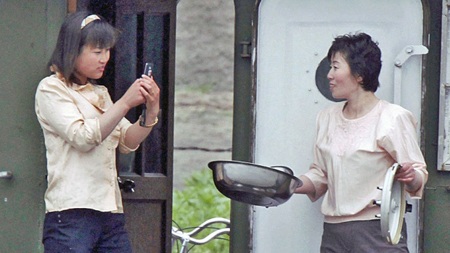 Triều Tiên: Rộ mốt tặng điện thoại thay nhẫn cưới - 1 Một phụ nữ Triều Tiên dùng đoại thoại di động chụp ảnh