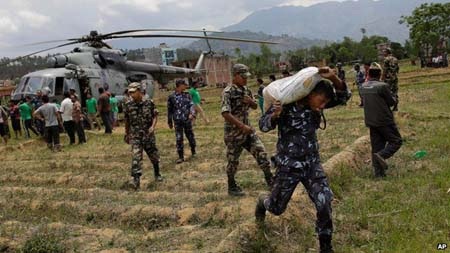 90% binh sỹ Nepal tham gia cứu hộ, số người chết vượt 4.300 - 1 Một binh sỹ quân đội Nepal chuyển hàng cứu trợ ra khỏi một trực thăng của Ấn Độ (Ảnh: AP)