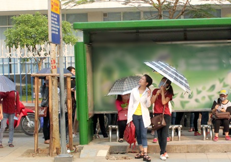 Nắng nóng dội trên mặt đường bê tông hầm hập nóng, ai cũng cố tìm một bóng mát. (Ảnh: Quang Phong)