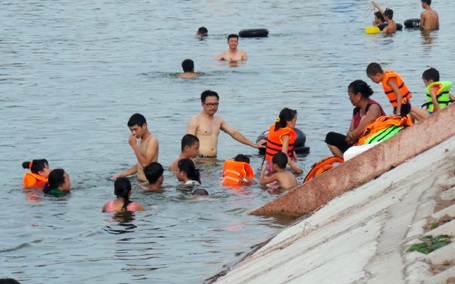 Các em nhỏ cũng được người lớn cho ra ven hồ tắm mát