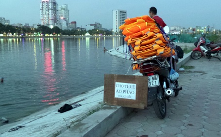 Dịch vụ cho thuê áo phao (10.000 đồng/chiếc) ăn theo những ngày nắng nóng ở hồ Linh Đàm.
