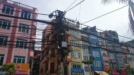 Hà Nội: Hàng chục cột điện “thử tay lái” người đi đường - 4 Những cây cột điện này còn bị đu bởi những mớ dây nặng trĩu, nguy cơ gãy đổ rất cao