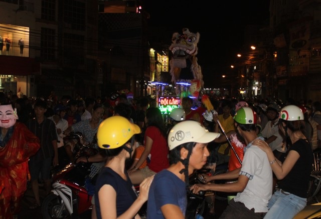 Đường phố chật kín người đi xem múa lân.