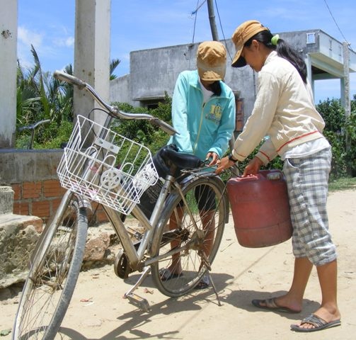 Hàng ngày 2 chị em Thu và Hà phải đạp xe 4 km để lấy nước sạch về bán mỗi chuyến lãi 500 đồng.