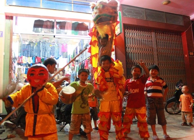 Các bậc phụ huynh đưa con em đi chơi đêm hội trăng Rằm. (Ảnh: Doãn Công)