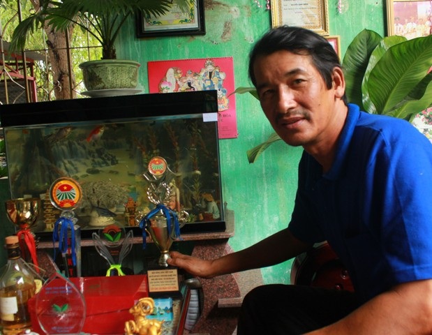 Nhà sáng chế chân đất Nguyễn Kim Chính với những tấm huy chương, huy hiệu - Ảnh: Doãn Công.