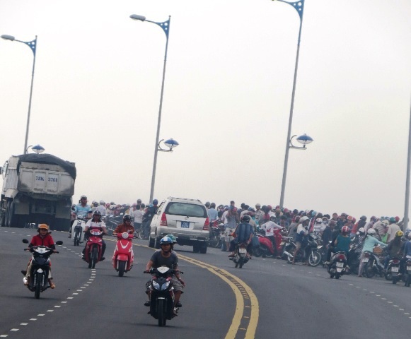 Nhiều người đi đường tụ tập trên cầu Hùng Vương theo dõi vụ việc.