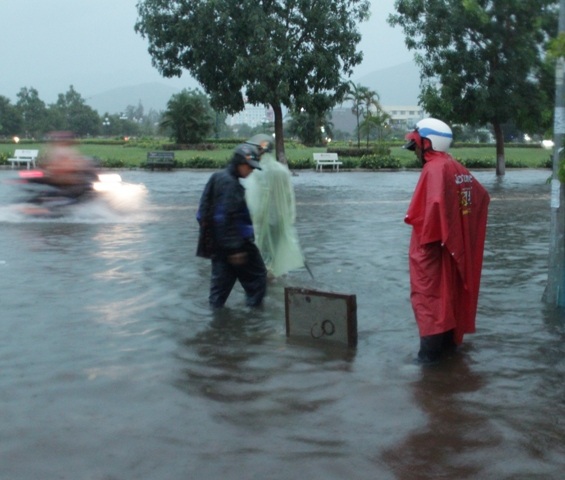 Công nhân cấp thoát nước TP đang cạy nắp cống trên đường để thoát nư