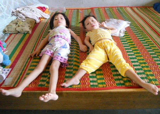 Kỳ lạ 3 anh em cứ đến 8 tháng tuổi thì chân tay "mềm như bún" - 1 Hai cháu Huy và Hạo nằm liệt giường mà cha mẹ thì không có tiền chữa trị