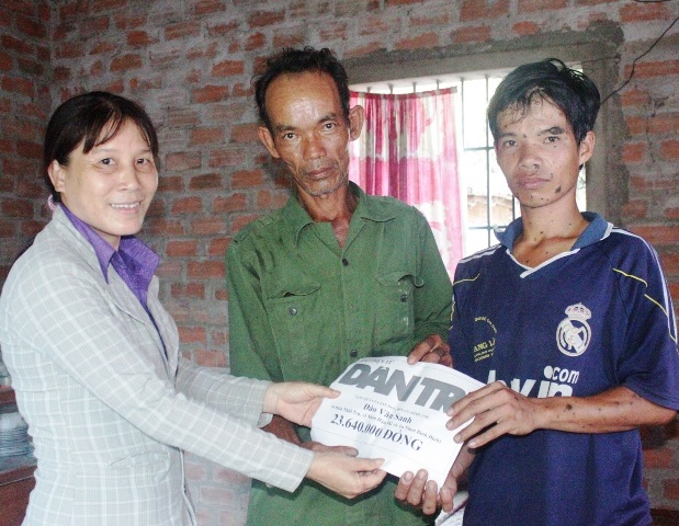 Đại diện xã Nhơn Hậu trao quà bạn đọc Dân trí đến hoàn cảnh anh Sanh và cháu Đông