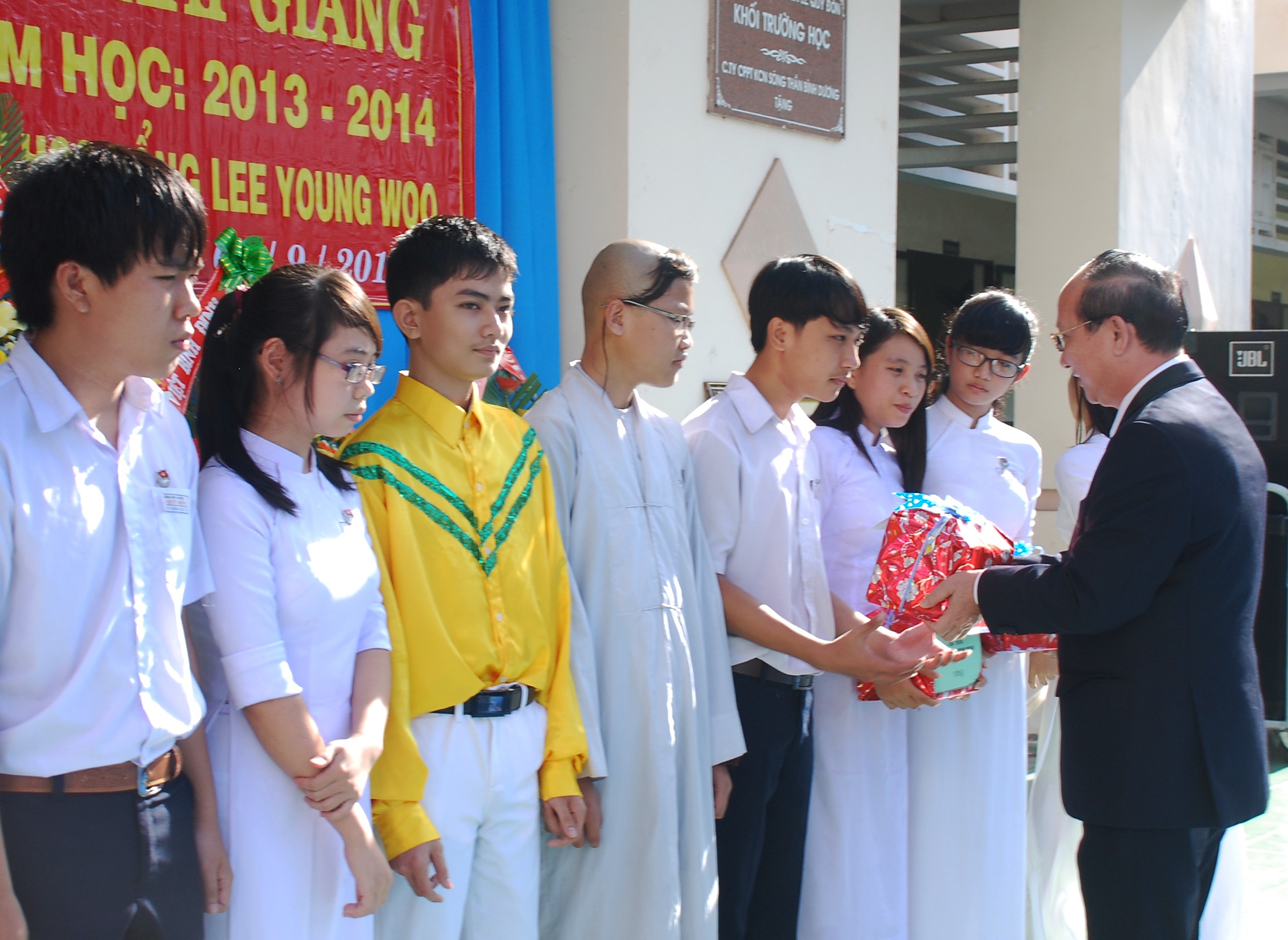 Ông Lê Hữu Lộc trao quà đến học sinh nghèo học giỏi. (Ảnh: Hoa Khá).