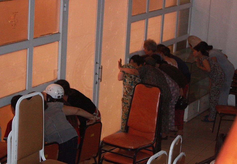 Nhiều người hiếu kỳ cố nhìn qua ô kính mờ để nhìn cô dâu chú rể