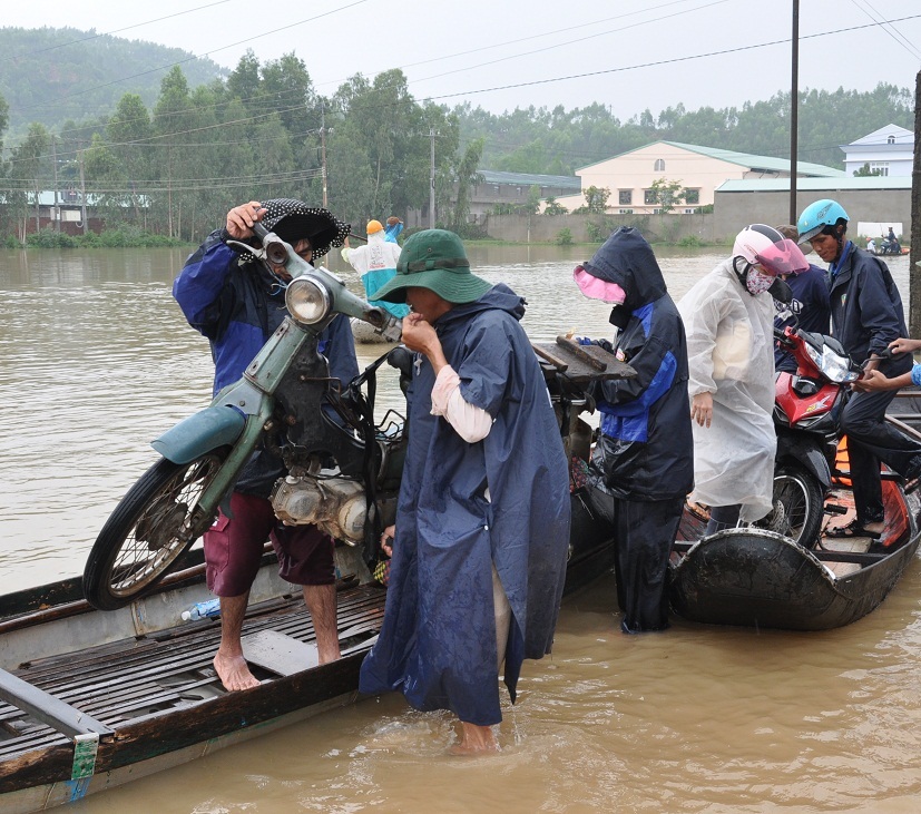 Tỉnh lộ ĐT 640 qua huyện Tuy Phước bị nước lũ chia cắt người dân phải đi lại bằng ghe