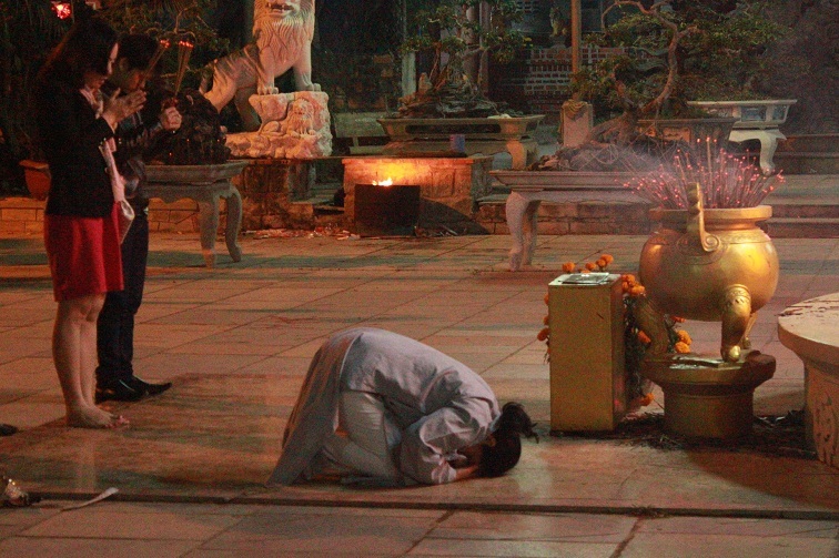 Chắp tay cầu may trước đức phật từ bi 