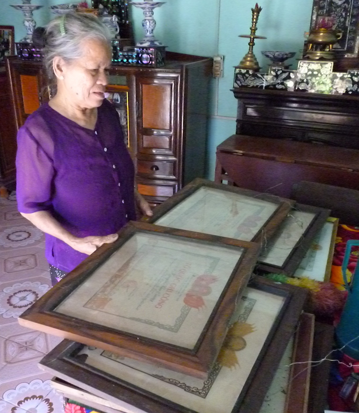 Bà Đào lấy những tấm Huân chương kháng chiến của chồng và con đã hy sinh cho Tổ quốc.