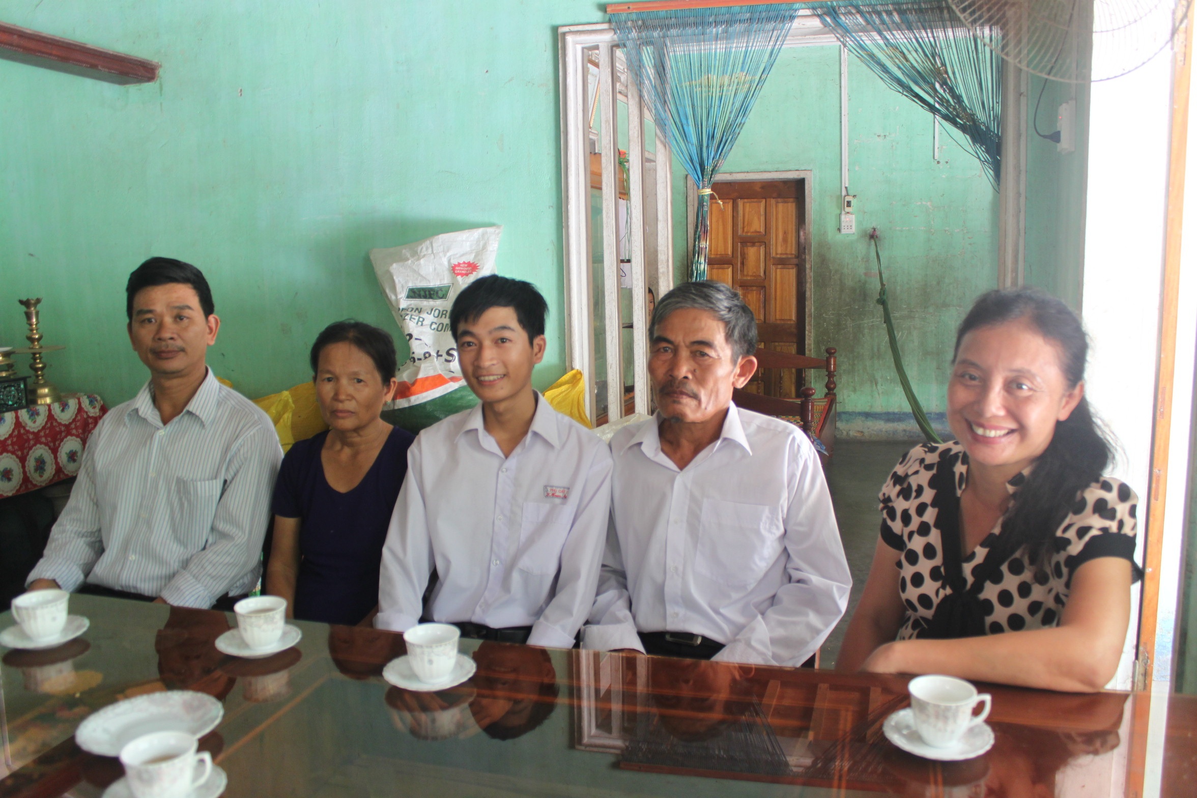 Nam chia sẻ niềm vui cùng ba mẹ và thầy cô của trường nơi em học