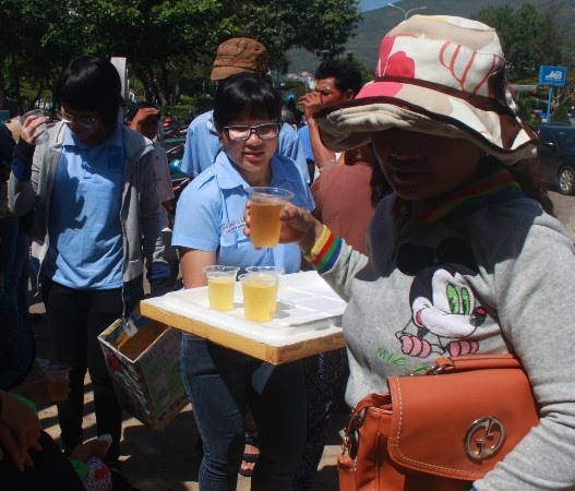 Tình nguyện viên bê trà đá đến mời từng phụ huynh.