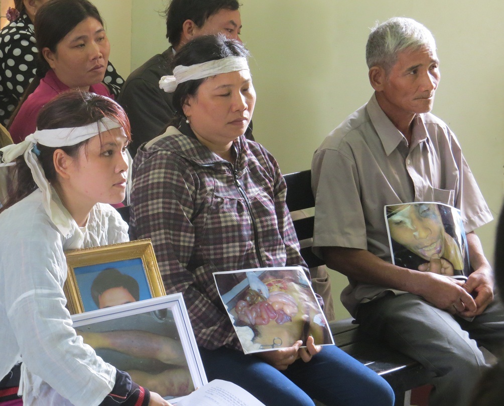 Gia đình bị hại ôm di ảnh chụp các vết thương của anh Kiều trước khi bị đánh chết