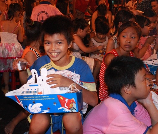 Em Vũ thích thú được nhận bánh và đèn lồng hình con tàu 