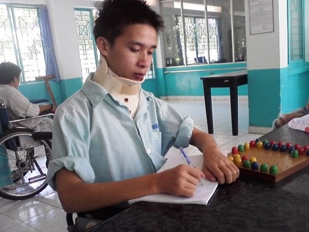 Gần 60 triệu đồng đến với cậu sinh viên đi làm thêm gặp nạn - 1 Nguyễn Thanh Huy ngồi xe lăn tập cử động bàn tay (Ảnh: Chí Thanh)