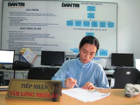 Chị Kiều làm thủ tục nhận 128.090.000 đồng do bạn đọc Dân trí ủng hộ