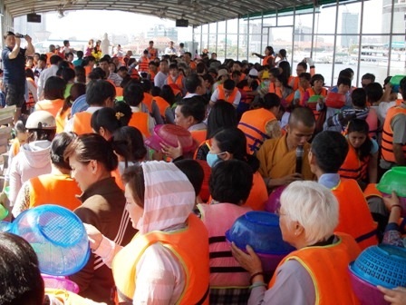 Đi tàu phóng sinh trên sông Sài Gòn - 4 Mọi người di chuyển theo chiều kim đồng hồ để nhận và thả cá, miệng luôn niệm A Di Đà