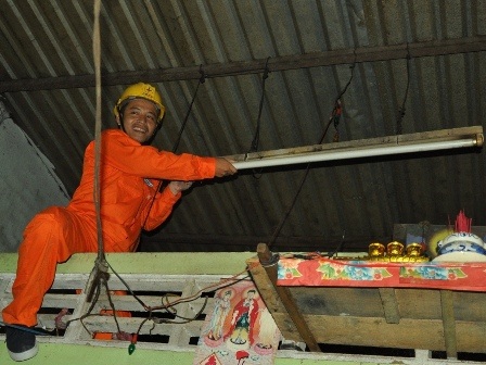 Các xã nghèo Tiền Giang hưởng ứng Hành trình Tiết kiệm điện 2013 - 5 Nhân viên điện lực hỗ trợ các hộ gia đình lắp đặt bóng đèn mới
