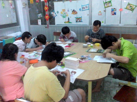 Cô giáo Bé (áo hồng nhạt) hướng dẫn các em luyện tập thêu chữ thập, thêu tranh hạt đá, kết cườm...