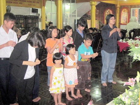 Bé Nhân Hòa thắp nhang cho chị Nhân Ái