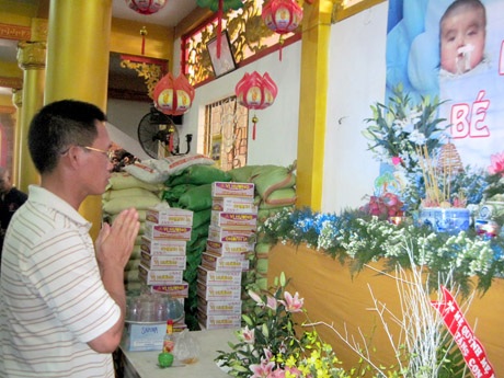 Bé Nhân Hòa thắp nhang cho chị Nhân Ái