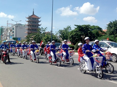 100 đôi uyên ương thành hôn ngày 2/9 - 2 Các cô dâu, chú rể diễu hành xe đạp điện qua các tuyến đường để đến dâng hương tại tượng đài Bác Hồ