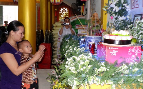 Bé Nhân Hòa thắp nhang cho chị Nhân Ái