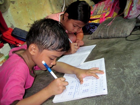 Hai chị em Như và Nghĩa nắn nót từng con chữ bằng bàn tay trầy trụa.