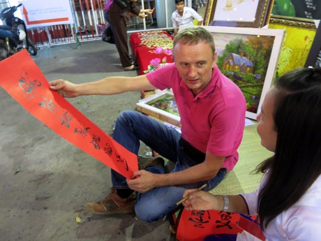 Anh bạn người Hà Lan yêu mến thư pháp Việt đến phụ giúp chị Kim Yến quản lý gian hàng