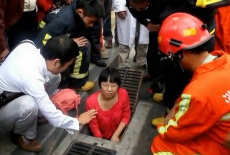 Cô gái mắc kẹt dưới cống vì cố nhặt điện thoại bị đánh rơi - 1 Cô gái đang bị mắc kẹt trong cống và nỗ lực cứu hộ của những người xung quanh